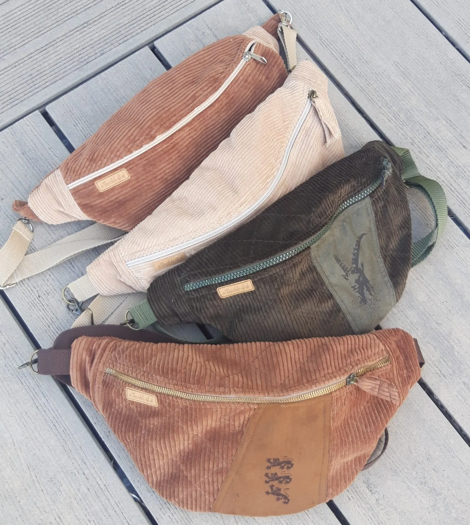 Vier Bauchtaschen aus Cord in Braun-, Beige- und Grüntönen